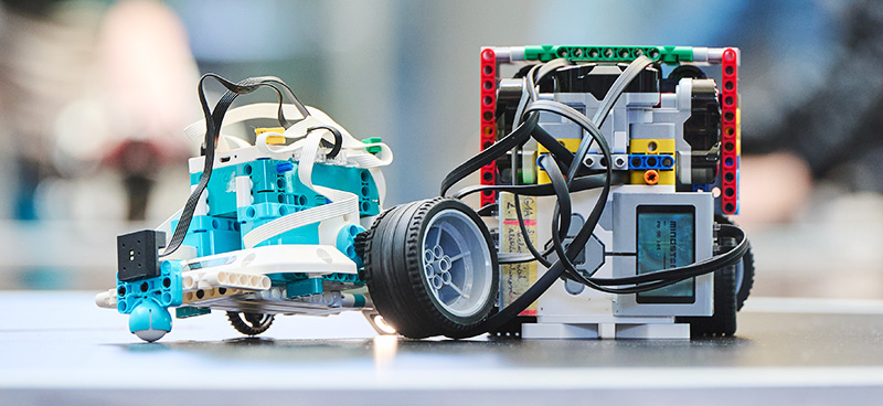 Dva roboti ze stavebnice LEGO na soutěžní ploše